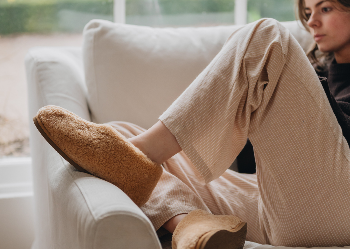 Womens Sheepskin Slipper Lili Rust Slingback On Lady with feet up on the Sofa