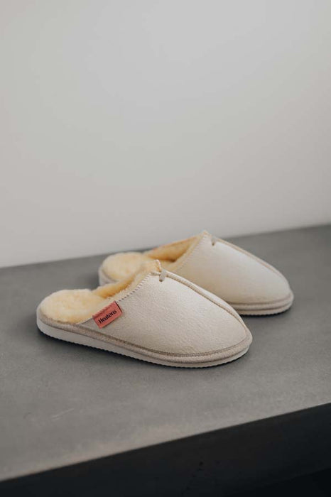 Side View of Alys Eco Sheepskin Slippers on Concrete Surface
