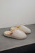 Side View of Alys Eco Sheepskin Slippers on Concrete Surface