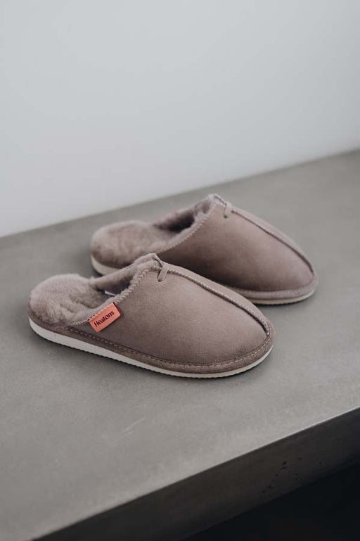 Side View of Alys Stone Sheepskin Slippers on Concrete Surface