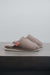 Side View of Alys Stone Sheepskin Slippers on Concrete Surface