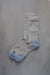 Pair of beige socks with blue toe post and heel on a grey background