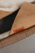Close up of a pair of tan merino sheepskin men's mule slippers with an orange cork Heaton's label