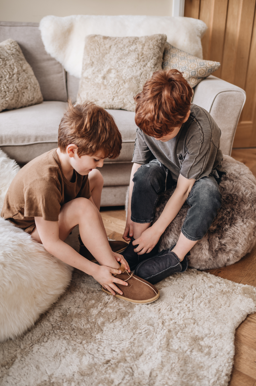 General image of sheepskin products, featuring cushion, rugs, ottomans and slippers.