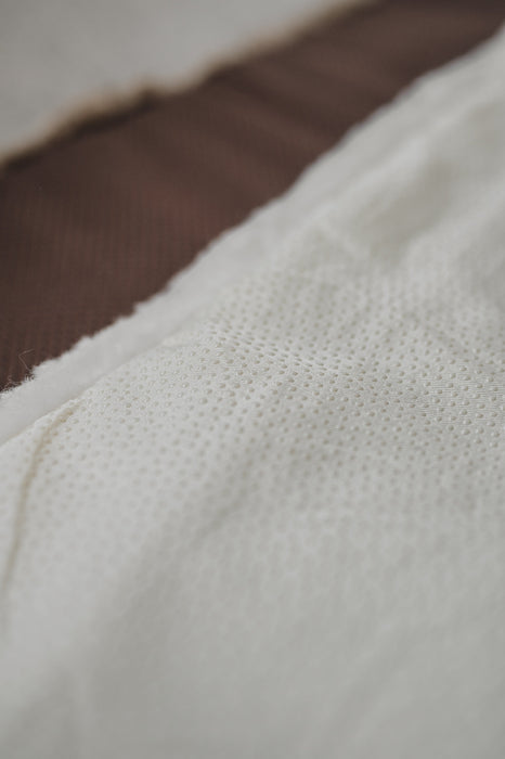 Close-up of a the rubber non
-slip underside of a white sheepskin pet bed