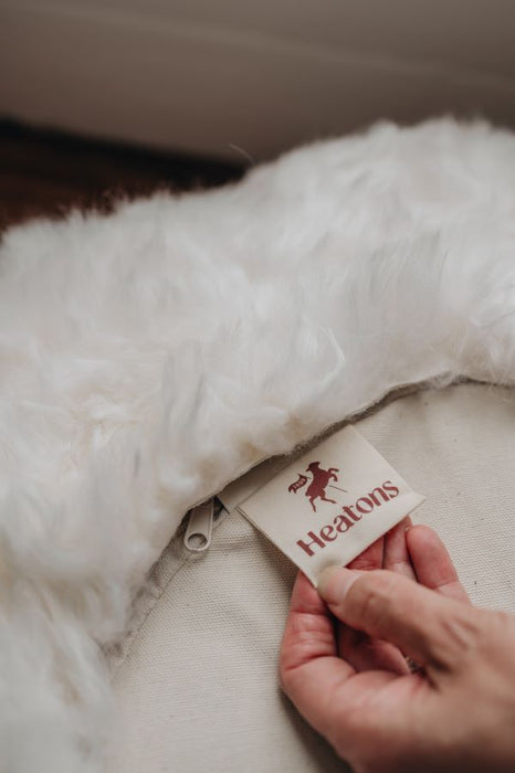 Close up of Heatons cotton label on underside of a white sheepskin floor cushion