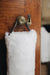 White sheepskin draught excluder with leather handle hanging on a wooden door with a brass doorknob and keyhole.