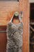 Wheat brown sheepskin draught excluder with leather handle hanging on a wooden door with a brass doorknob and keyhole.