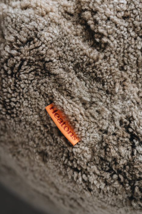 Orange cotton label with 'Heatons' branding on a wheat sheepskin beanbag.