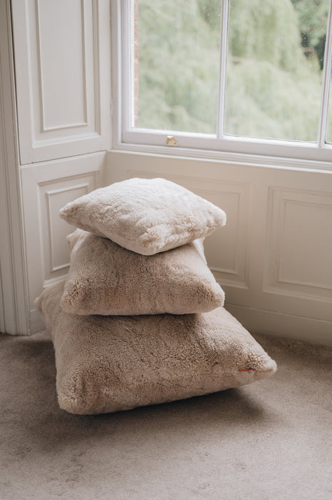Stack of sheepskin cushion in a room with a window in the background