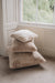 Stack of sheepskin cushion in a room with a window in the background