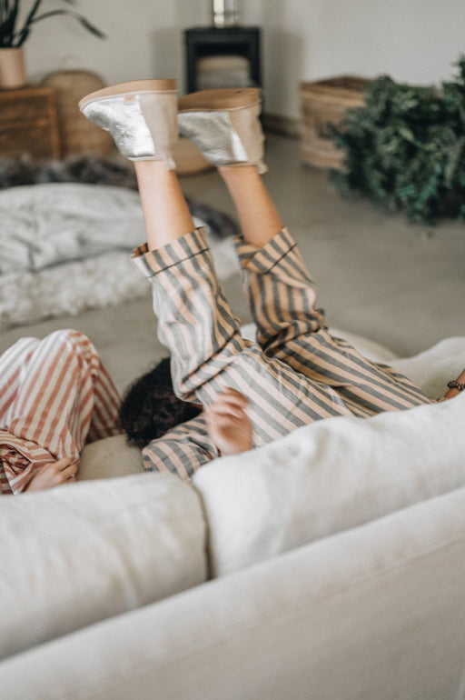 Lady wearing Erin Sheepskin Slippers falling back on a couch