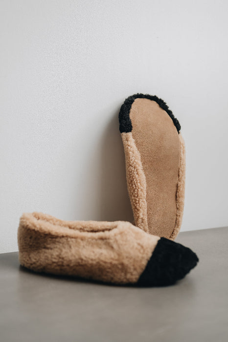 Bottom view of the soft suede sole of this ballerina style curly beige sheepskin slipper with black toe point