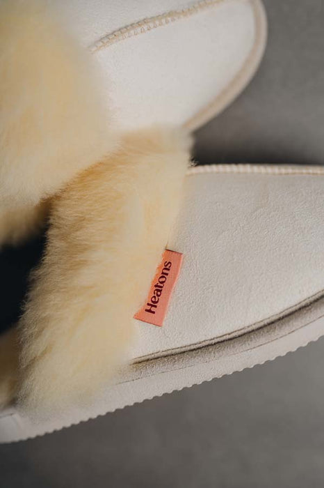 Close up View of Gwen Sheepskin Slippers in Eco with Heatons label detail on Concrete Surface