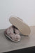 Gwen Stone Sheepskin Slippers showing the bottom of the EVA sole on a Concrete Surface