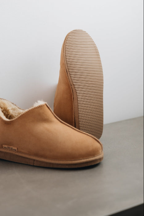Close up of Tan coloured ankle-high sheepskin slipper showing the ribbed underside of the PVA sole