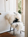 Icelandic natural spotted sheepskin white and black draped over a chair