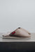 Side View of Idris Walnut Sheepskin Slippers on Concrete Surface