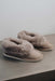 Side View of Ruby Stone Sheepskin Slippers on Concrete Surface
