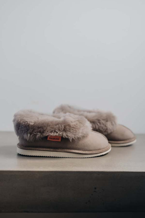 Side View of Ruby Stone Sheepskin Slippers on Concrete Surface