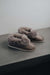 Side View of Ruby Walnut Sheepskin Slippers on Concrete Surface