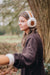 Sheepskin Earmuffs on young brown haired woman in brown wool jumper.