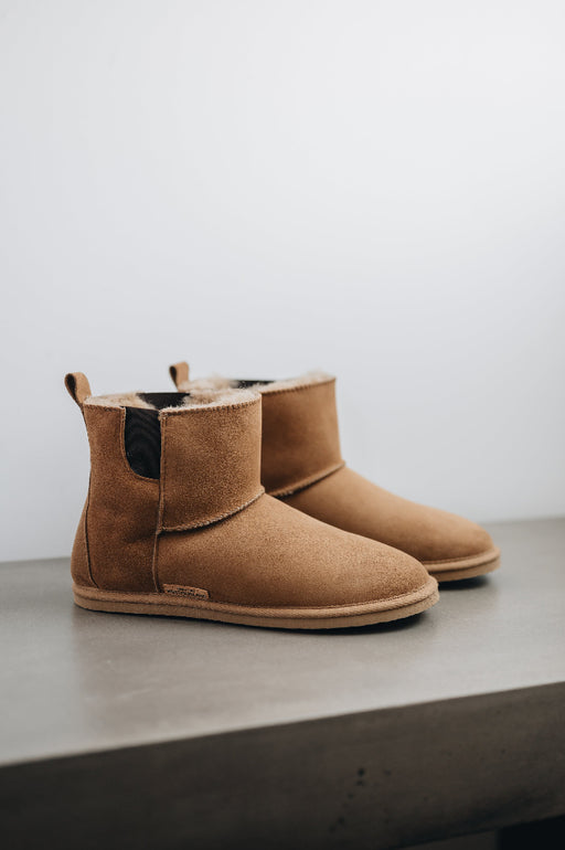 Side view of the Sheepskin, Chelsea boot style, slipper. A classic sheepskin boot with elastic panels on both sides.