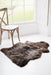 Soft Natural Brown British Sheepskin Rug contrasting against a hard and stark white wooden floor next to a traditional wooden chair in a window.