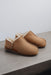 Side View of Cadi Mel Sheepskin Slippers on Concrete Surface
