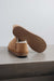 Cadi Tabac Sheepskin Slippers showing the bottom of the EVA sole on a Concrete Surface