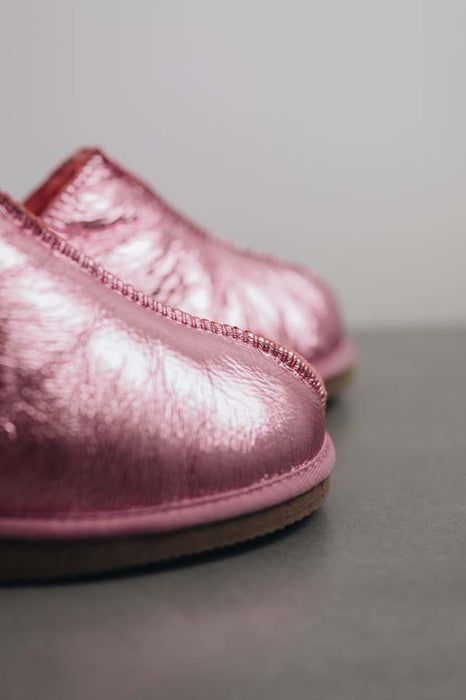 Close up View of Cadi Metallic Pink Sheepskin Slippers on Concrete Surface