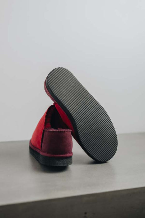 Cadi Red Sheepskin Slippers showing the bottom of the EVA sole on a Concrete Surface