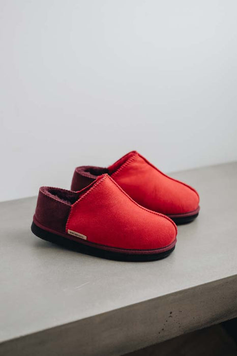Side View of Cadi Red Sheepskin Slippers on Concrete Surface