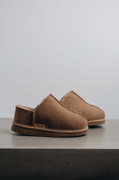 Side view of Cadi Taupe Sheepskin Slippers on Concrete Surface
