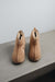 A pair of tan merino sheepskin ankle boots with a soft cream lining called Erin.  Displayed on a concretebench against a light grey wall.