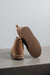 A pair of tan genuine sheepskin ankle boots, with one boot standing upright and the other leaning on its side to show the textured sole, set against a minimalist grey background.