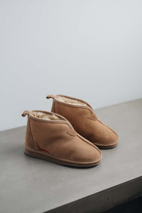 Side view of Erin women's Sheepskin Slippers in Tabac on Concrete Surface