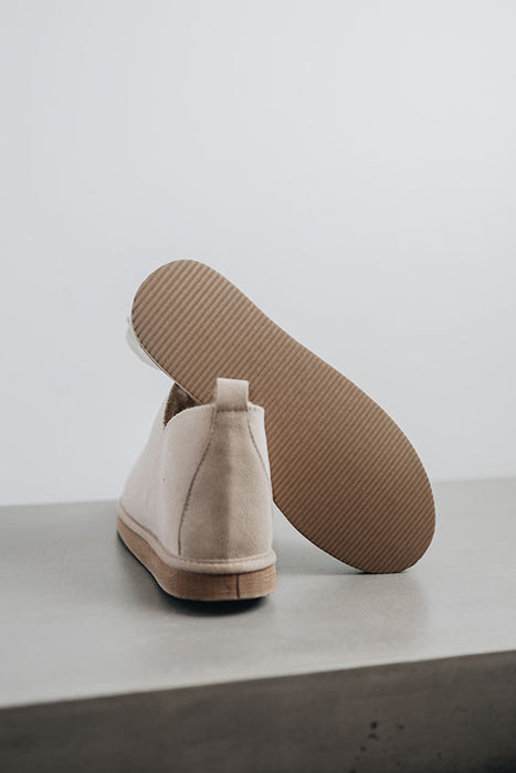 Close up of Vanilla coloured ankle-high sheepskin slipper showing the ribbed underside of the PVA sole