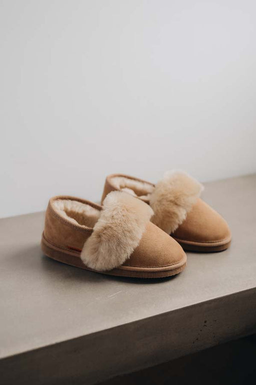 Side view of Margot Tabac Sheepskin Slippers on Concrete Surface