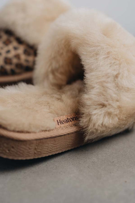 Close up view of Veronica Leopard Sheepskin Slippers with Heatons label detail on Concrete Surface
