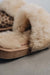 Close up view of Veronica Leopard Sheepskin Slippers with Heatons label detail on Concrete Surface