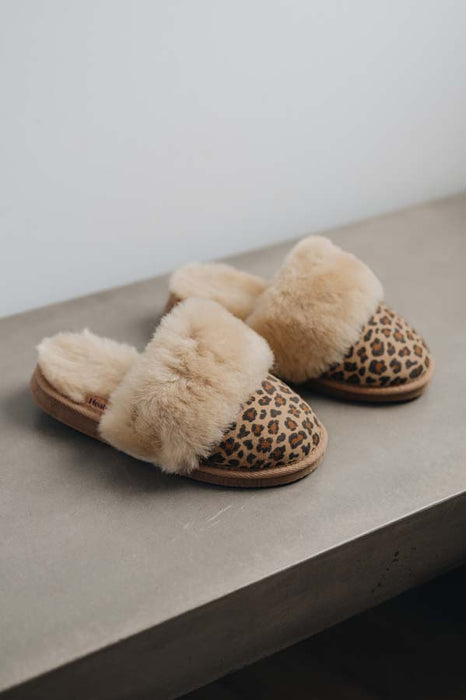 Profile view of Veronica Leopard Sheepskin Slippers on Concrete Surface