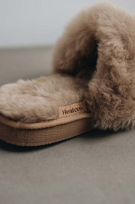 Close up view of Veronica Taupe Sheepskin Slippers with Heatons label detail on Concrete Surface