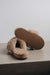 Veronica Taupe Sheepskin Slippers showing the bottom of the EVA sole on a Concrete Surface