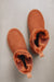 Birds eye view of a rust coloured sheepskin boot .