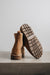 Tan sheepskin boots with a focus on the sole against a light grey stone background