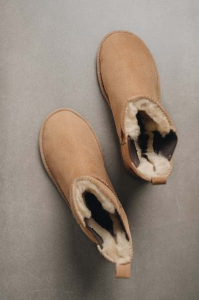 Birds eye view of tan sheepskin Chelsea boot style slippers.