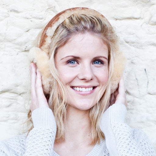 Natural Sheepskin Earmuffs, worn by a Blonde Female Model smiling.