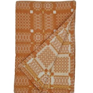 Melin Tregwynt Wool throw with an orange and white woven Knot Garden pattern