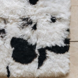 Designer Icelandic Sheepskin rug with natural black patterns on a tiled floor